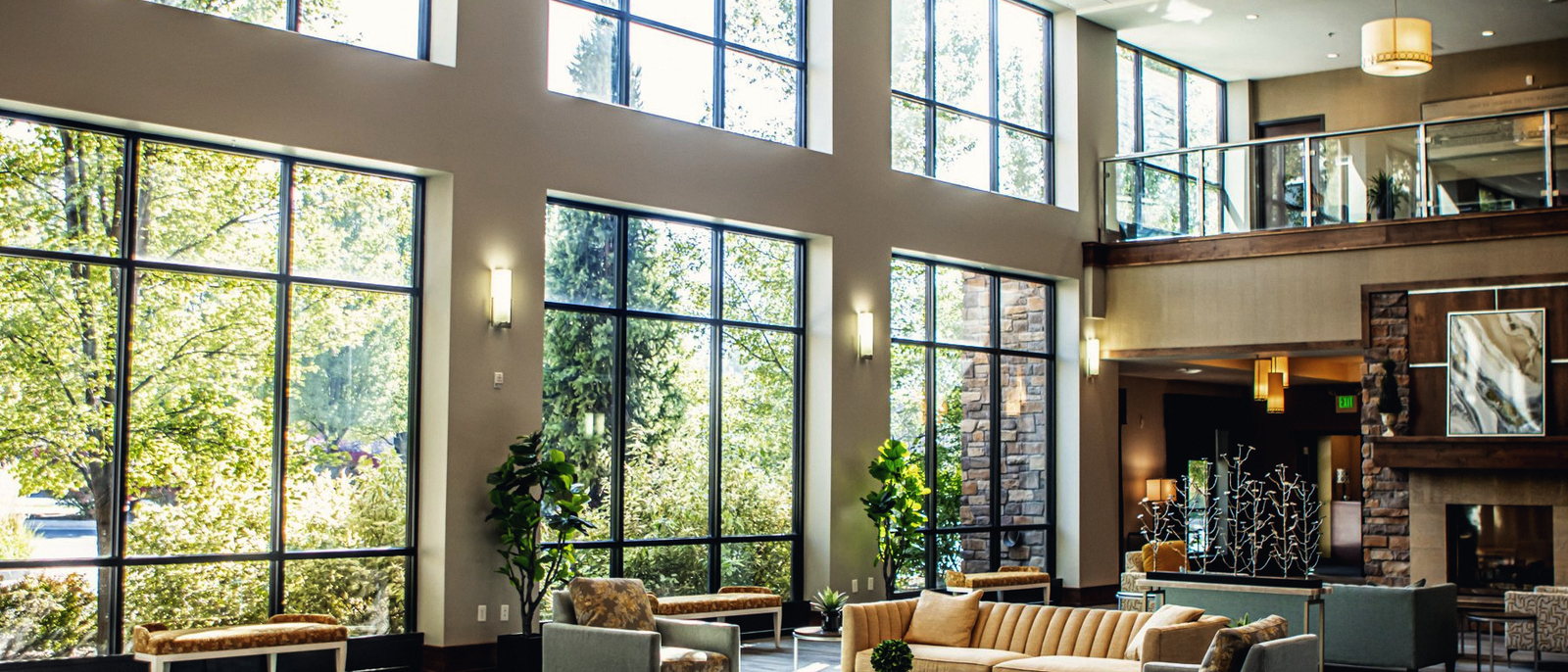 The double-height lobby, with tall windows onto trees, a stone fireplace and low seating.