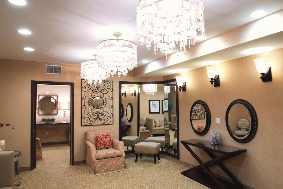 The Bridal Suite, empty, with chandeliers, wall mirrors and a settee.