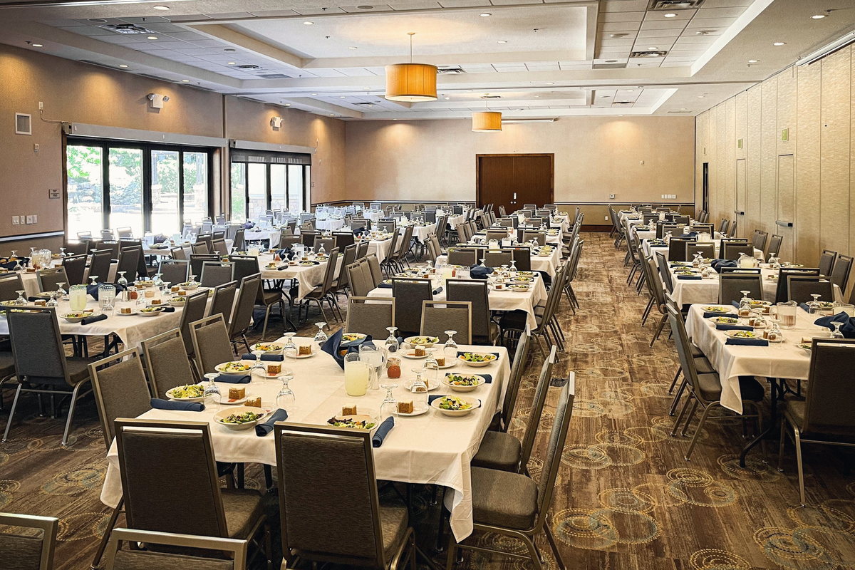The Mahogany and Redwood side of the ballroom set with round tables for a plated dinner.