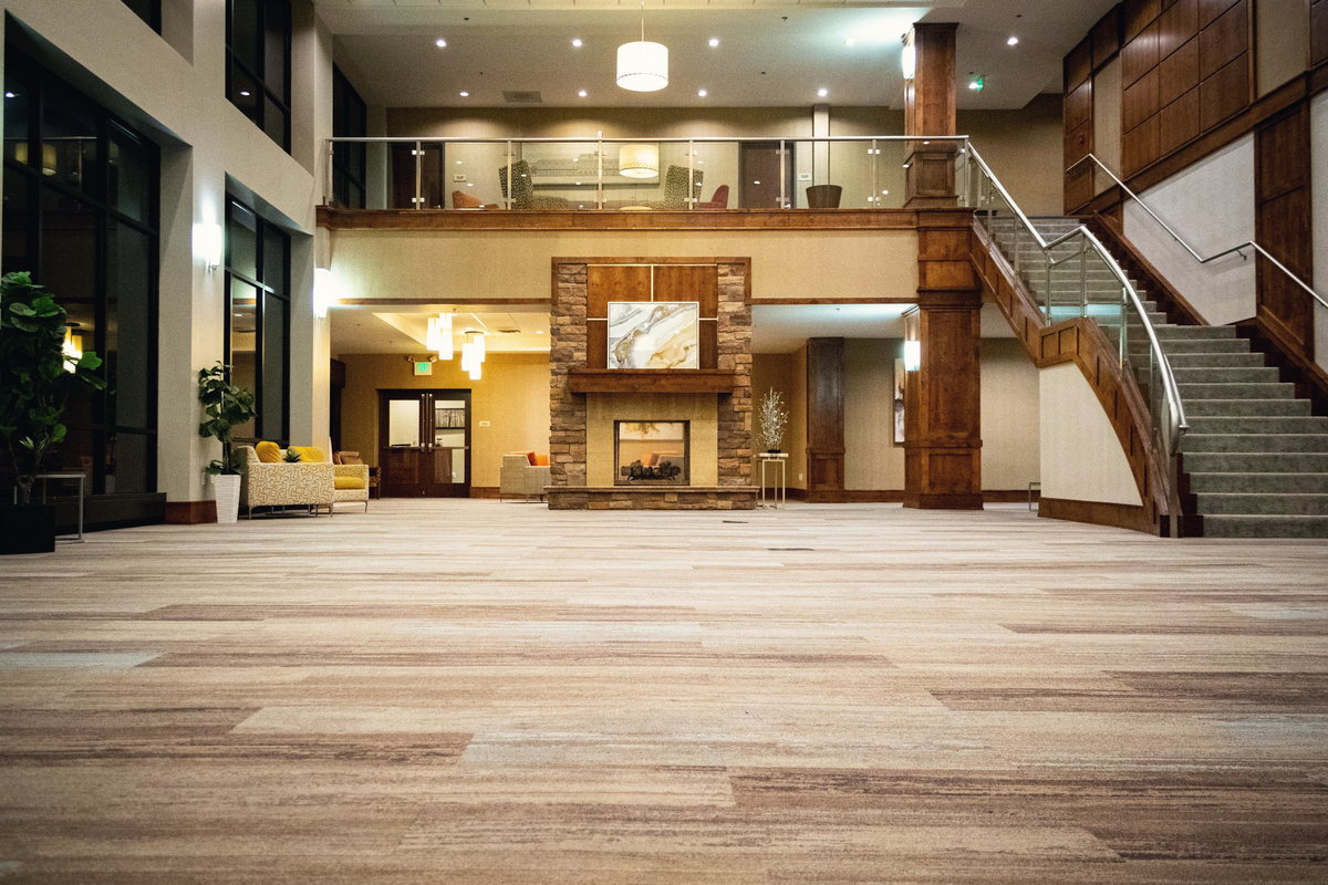 The Grand Reception Hall at night, empty, looking toward the stone fireplace and the curved staircase.